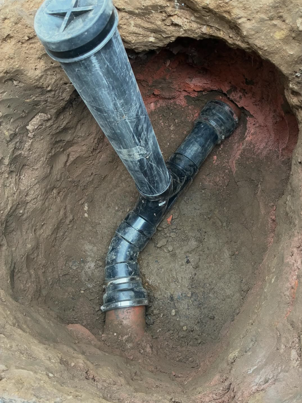 Close-up of pipework being repaired under a floor