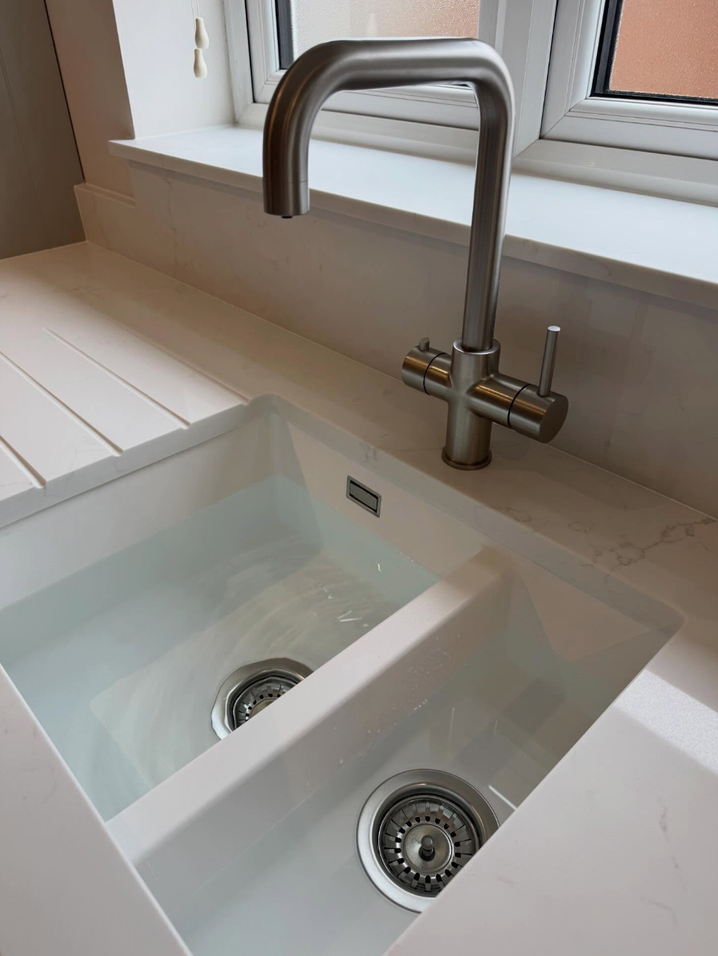 Close-up of a chrome kitchen faucet with running water